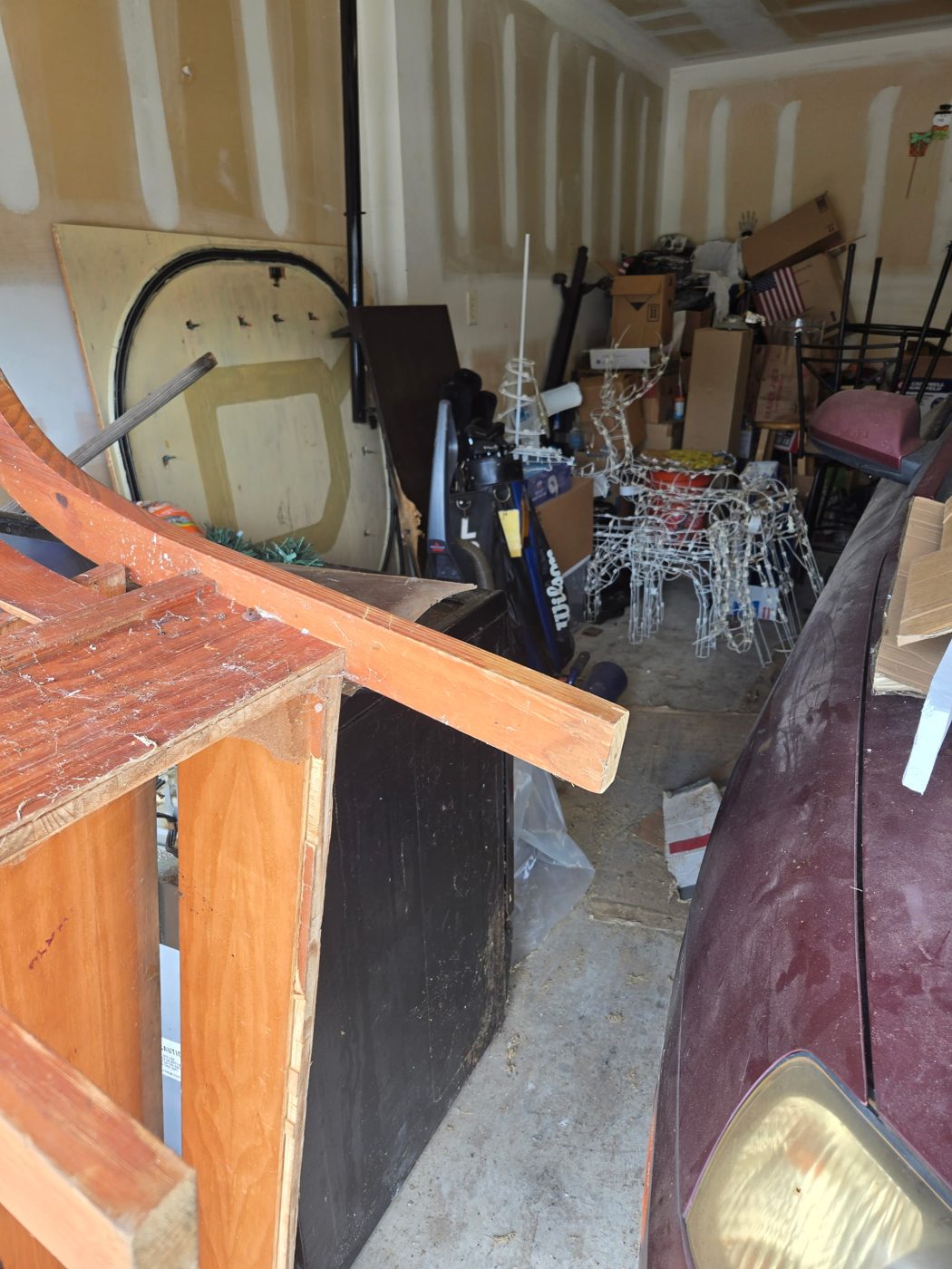 Cluttered garage packed with furniture and boxes before cleanout